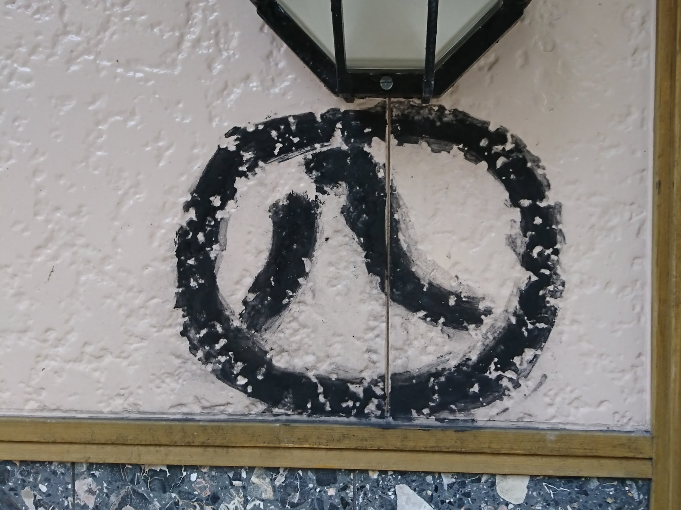 壁に描かれた丸の中に漢数字の八の文字